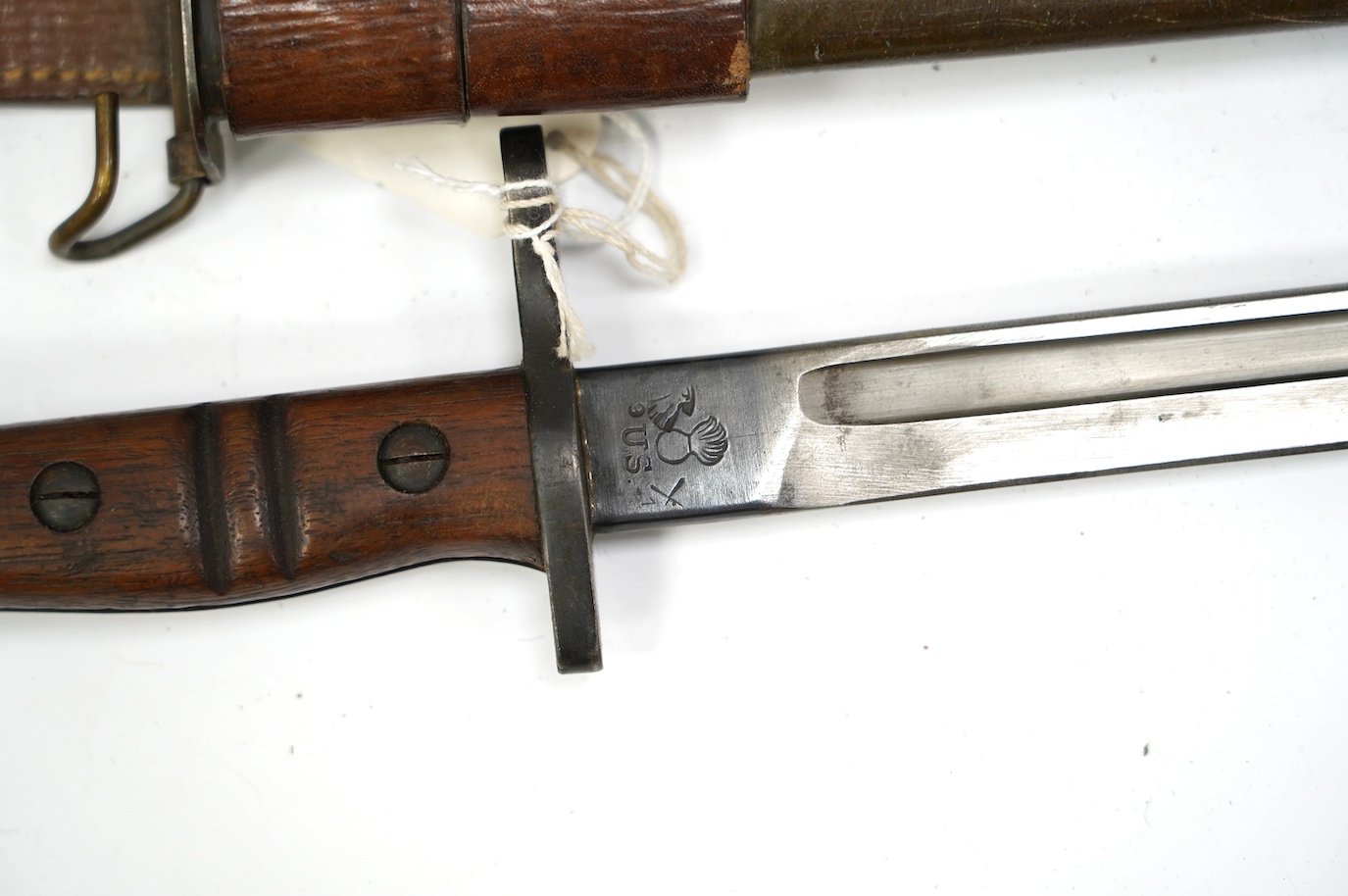 An American 1917 Remington bayonet, based on the earlier British bayonet of 1913, adapted for the 0.3 to 0.6 calibre rifles, with its leather covered scabbard. Condition - good